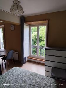 a bedroom with a bed and a window and a table at appartement T1 hyper centre 350 m des thermes 200 m des télécabines deuxième étage avec ascenseur in Luchon