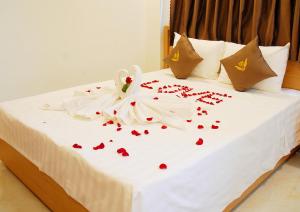 a white bed with red hearts on it at Trang Ngan Hotel by THG in Danang