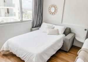 - une chambre avec un lit, un canapé et une fenêtre dans l'établissement Privately Owned Hotel Room in Beachside Resort - Sleeps 4, à Marcoola