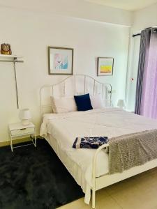 1 dormitorio con cama blanca y ventana en 3 Bedroom Apartment - Iconic Residences Colombo en Sri Jayewardenepura Kotte