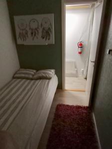 um quarto com uma cama e uma porta com um tapete vermelho em Ackes Stuga 32 em Örebro