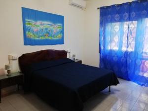 a bedroom with a bed and a painting on the wall at Sun & Beach Vasco De Gama by ACS HOLIDAYS in Lido di Ostia