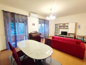 a living room with a red couch and a table at Sun & Beach Vasco De Gama by ACS HOLIDAYS in Lido di Ostia