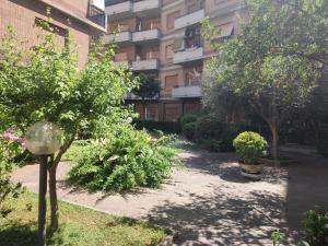 a courtyard in front of a building with trees and bushes at Sun & Beach Vasco De Gama by ACS HOLIDAYS in Lido di Ostia