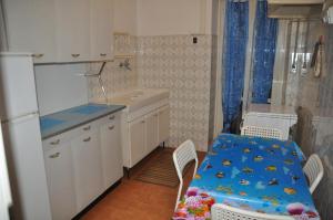 a kitchen with a blue table and chairs and a refrigerator at Sun & Beach Vasco De Gama by ACS HOLIDAYS in Lido di Ostia +41 photos