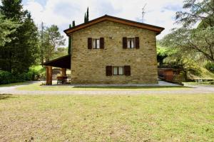 a stone house with a large yard in front of it at Beautiful country house in the heart of Tuscany in Capolona