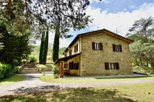a large stone house with trees in the background at Beautiful country house in the heart of Tuscany in Capolona