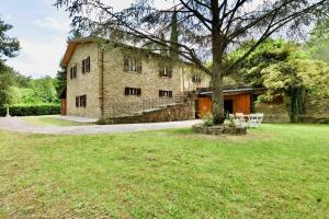 an old stone building with a tree in the yard at Beautiful country house in the heart of Tuscany in Capolona