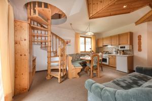 a kitchen and a living room with a spiral staircase at Gästehaus Gratz - inklusive Eintritt in die Alpentherme in Dorfgastein