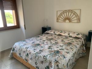 una camera con un letto con una trapunta sopra di Casa vacanze Marubium a Maruggio