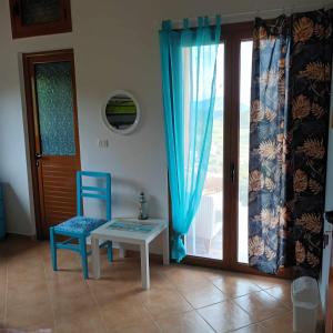a room with a table and a blue chair and a door at Pablo's Moto Inn 