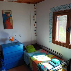 a bedroom with a bed and a dresser and a window at Pablo's Moto Inn 