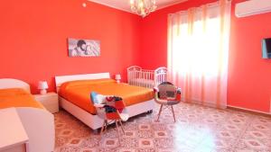 a red bedroom with two beds and a window at Casa Vacanze Ramo in Mazara del Vallo