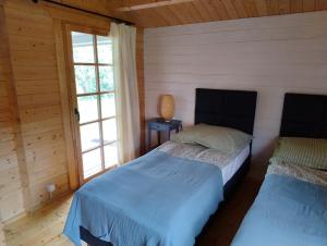 a bedroom with two beds and a window at Domki Przy Orzechu in Lubin