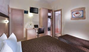 a hotel room with two beds and a desk with a computer at Hotel Rubens in Rimini