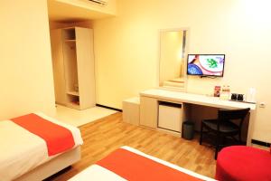 Habitación con cama y escritorio con espejo. en Halogen Hotel Airport Surabaya, en Sidoarjo