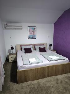 a bedroom with a large bed with a purple wall at Pansion Infinity in Mostar