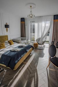 a bedroom with a large bed and a living room at Prawdzic Family Resort & Wellness in Gdańsk