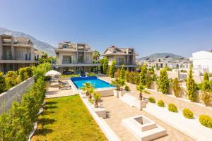 - une vue sur l'arrière-cour d'une maison avec piscine dans l'établissement Villa Moderno B, à Ölüdeniz