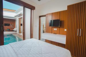 a bedroom with a bed and a swimming pool at Naturale Villa Ubud, Bali in Ubud
