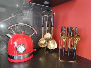 a red tea kettle and utensils on a counter at Studio - Sleeps 2 - WiFi - Aircon in Le Kremlin-Bicêtre