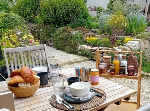 einen Tisch mit einem Frühstück mit Croissants und Kaffee in der Unterkunft Le Clos de l'Aiguillon 