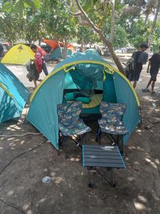 una tienda con 2 sillas y un niño en ella en Madasari Outdoor Camping Standar en Bulakbenda