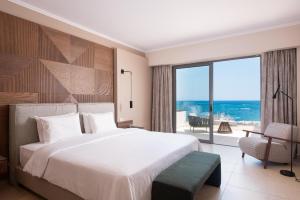 a bedroom with a large bed and a large window at KRESTEN ROYAL Euphoria Resort in Kallithea Rhodes