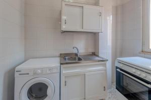 een kleine keuken met een wasmachine en een wastafel bij Carlo in San Pietro in Bevagna