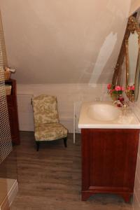 a bathroom with a sink and a chair at La Sévinais in Retiers +45 photos