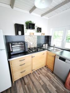 a kitchen with a stove and a sink at Chalet - gîte avec étang in Deneuvre