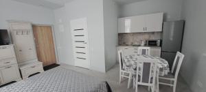 a kitchen with a table and a table and chairs at Apartamentai Mažvydo alėjoje in Klaipėda