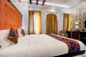 a bedroom with a large bed and a desk at FabHotel Mandiram Palace in Udaipur