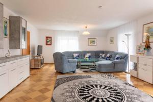 a living room with a couch and a table at Ferienwohnung Dreiländereck - Villach Land - Faaker See in Arnoldstein