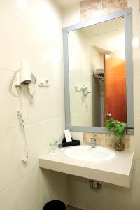 y baño con lavabo y espejo. en Halogen Hotel Airport Surabaya, en Sidoarjo