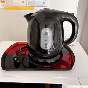 une cafetière noire sur un plateau sur un comptoir dans l'établissement LuckyHouse浅草 成田羽田直行, à Tokyo