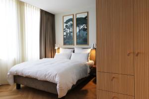 - une chambre avec un grand lit et des draps blancs dans l'établissement Hood House Kassel, à Cassel