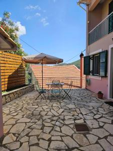 een patio met een tafel en een parasol bij Vivis house in Katochorion