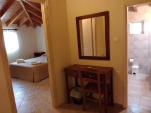 een badkamer met een wastafel, een spiegel en een bed bij Porto Fico Hotel in Vasiliki +44 foto's