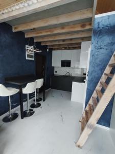 a kitchen with a black table and white chairs at Stania Glamour CENTRUM in Boszkowo-Letnisko
