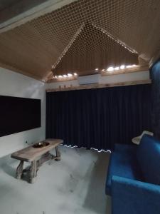 a room with a table and a screen and a blue couch at Stania Glamour CENTRUM in Boszkowo-Letnisko +2 photos