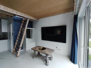 a living room with a tv and a wooden table at Stania Glamour CENTRUM in Boszkowo-Letnisko