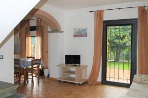 a living room with a television and a table with a television at Il Casale in Limite