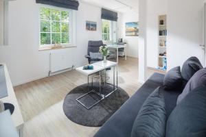 - un salon avec un canapé bleu et une table dans l'établissement Haus Bielefeld Ferienwohnung 14, à Norderney