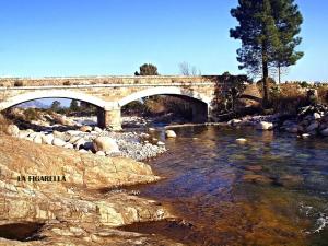 a stone bridge over a river with rocks at T1 bis avec mezzanine, belle terrasse et jardinet. in Moncale