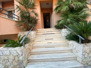 eine Treppe, die zu einem Gebäude mit Palmen führt in der Unterkunft Appartamento Kleos Balestrate in Balestrate