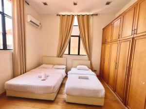 two beds in a room with a window at 4 Bedrooms PENTHOUSE MARINA COURT VACATION HOME KOTA KINABALU 14pax in Kota Kinabalu +20 photos