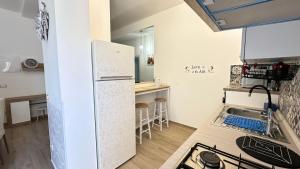 uma pequena cozinha com um frigorífico e um balcão em casa Mari, 250 mt dalle spiagge em Diano Marina