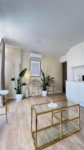 a living room with a glass table and some plants at Hermosos Apartamentos en pleno Centro in Granada