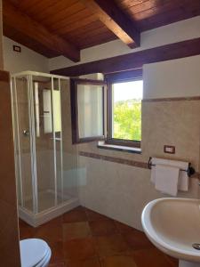 a bathroom with a glass shower and a sink at Country House B&B Antica Dimora Del Sole in Camerota
